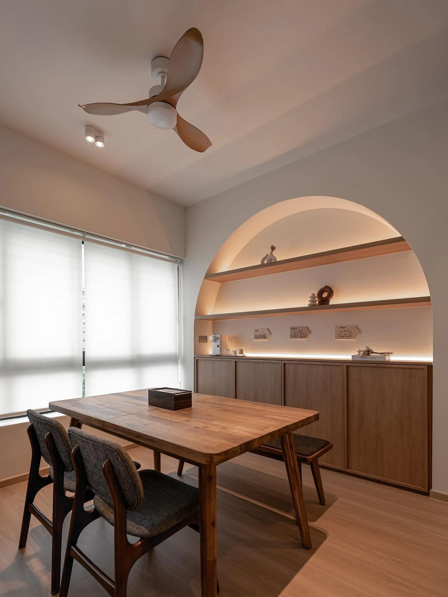 This home embraces the warmth of natural wood tones and the simplicity of clean lines. From the serene dining nook framed by a soft arch, to the bathroom&rsquo;s soothing textures, and the kitchen&rsquo;s seamless blend of function and form &mdash; e