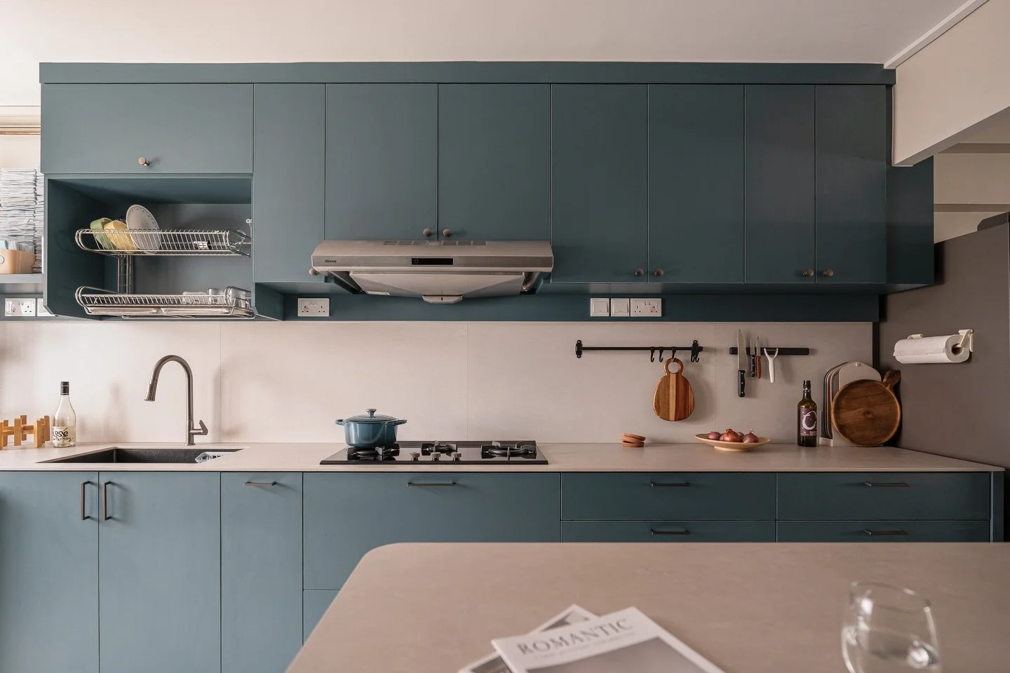 [2] While the living area was being adapted to new preferences, our owner's love for navy and turquoise tones took center stage in the kitchen. We chose a subtle stone look for the tabletop and backsplash that blends in with the living area's style. 