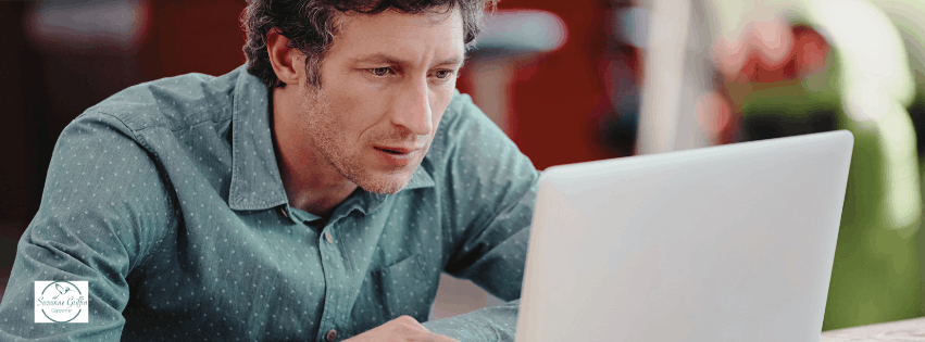 Man reading helpful therapist website content on his laptop.