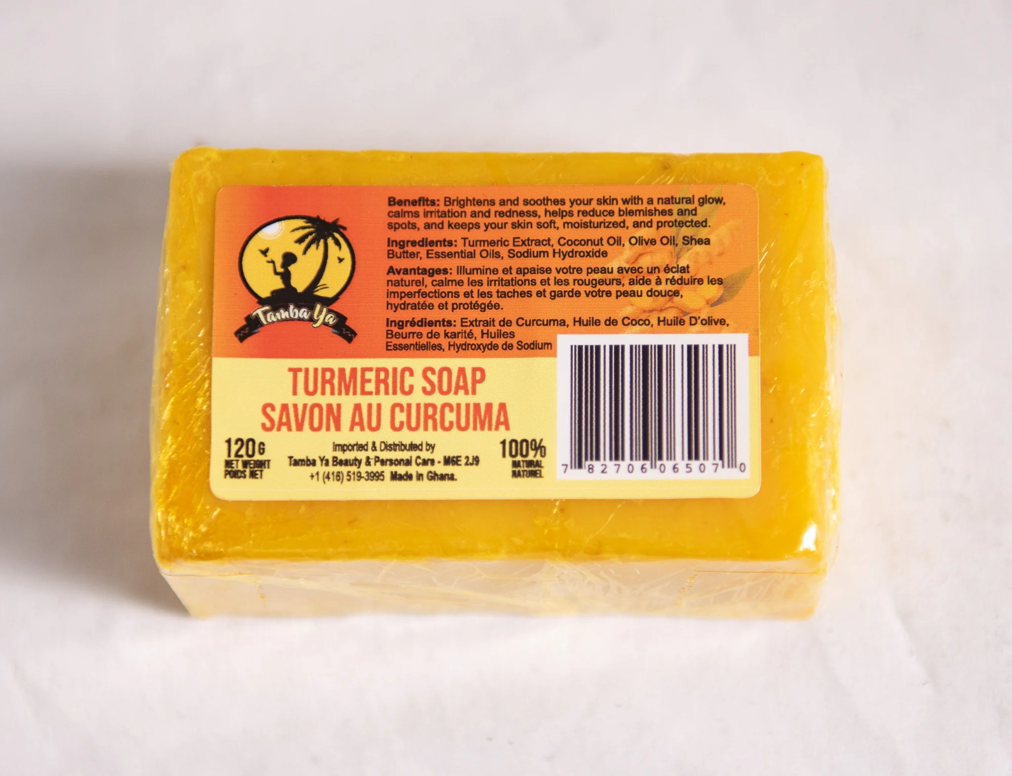 Yellow bar of turmeric soap with label showing product details and barcode.