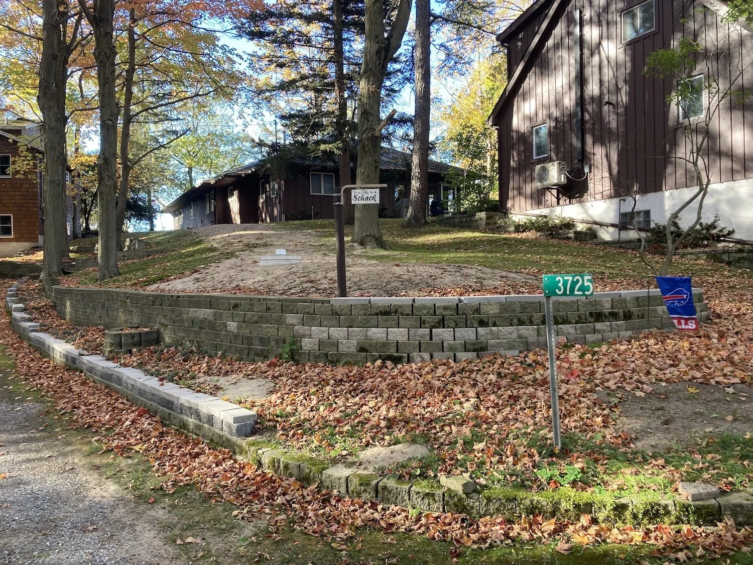 Here is the new retaining wall wrapping around the cistern. We raised the wall along the driveway and wrapped it around so we could back-fill to properly insulate and cover the cistern. Some how those blocks seemed much heavier than they did 35 years