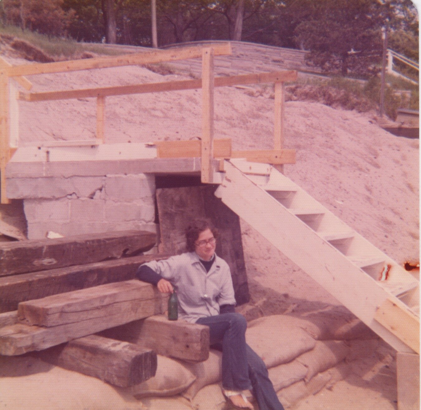 They then reinforced with more block to form a landing which is still there today. Sue is sitting on the sandbags we filled to protect the bank. The storm was so devastating dad couldn't get boulders or a contractor to install them until the next yea