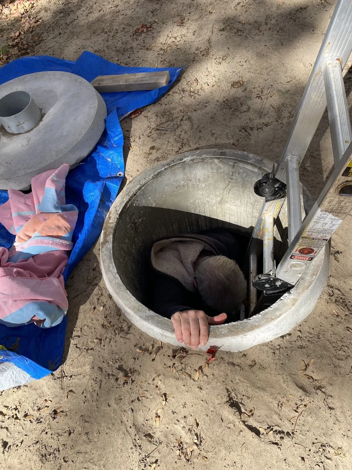Here I am dropping into the cistern with only 18 inches of water in the bottom. I'm wearing my headlight as it is quite dark, particularly with Pam watching carefully from above blocking the light. I appreciated the moral support and extra hands.