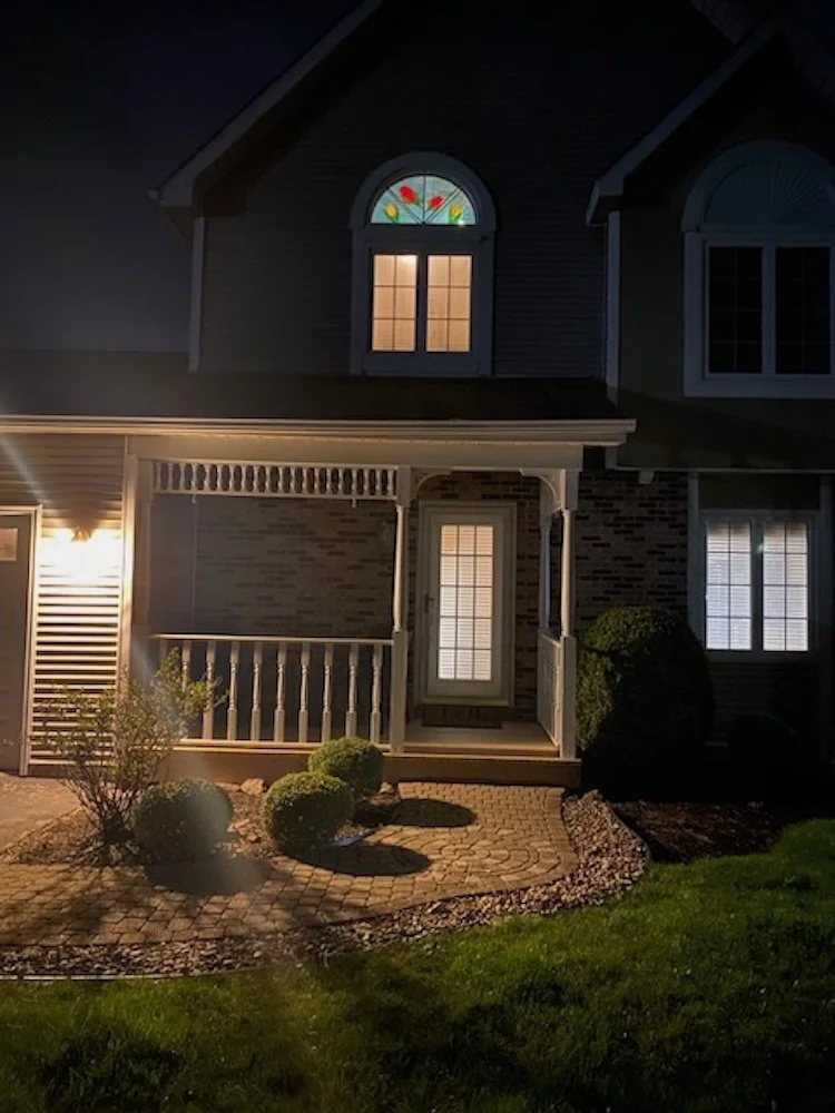 The window as viewed from the street when the track lights over the balcony are turned on.
