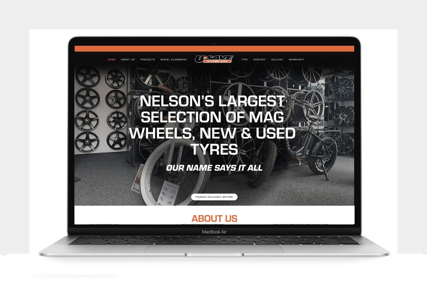 Screenshot of a website for Nelson's, a tire shop offering new and used mag wheels and tires, with a display of rims and bikes in the background.