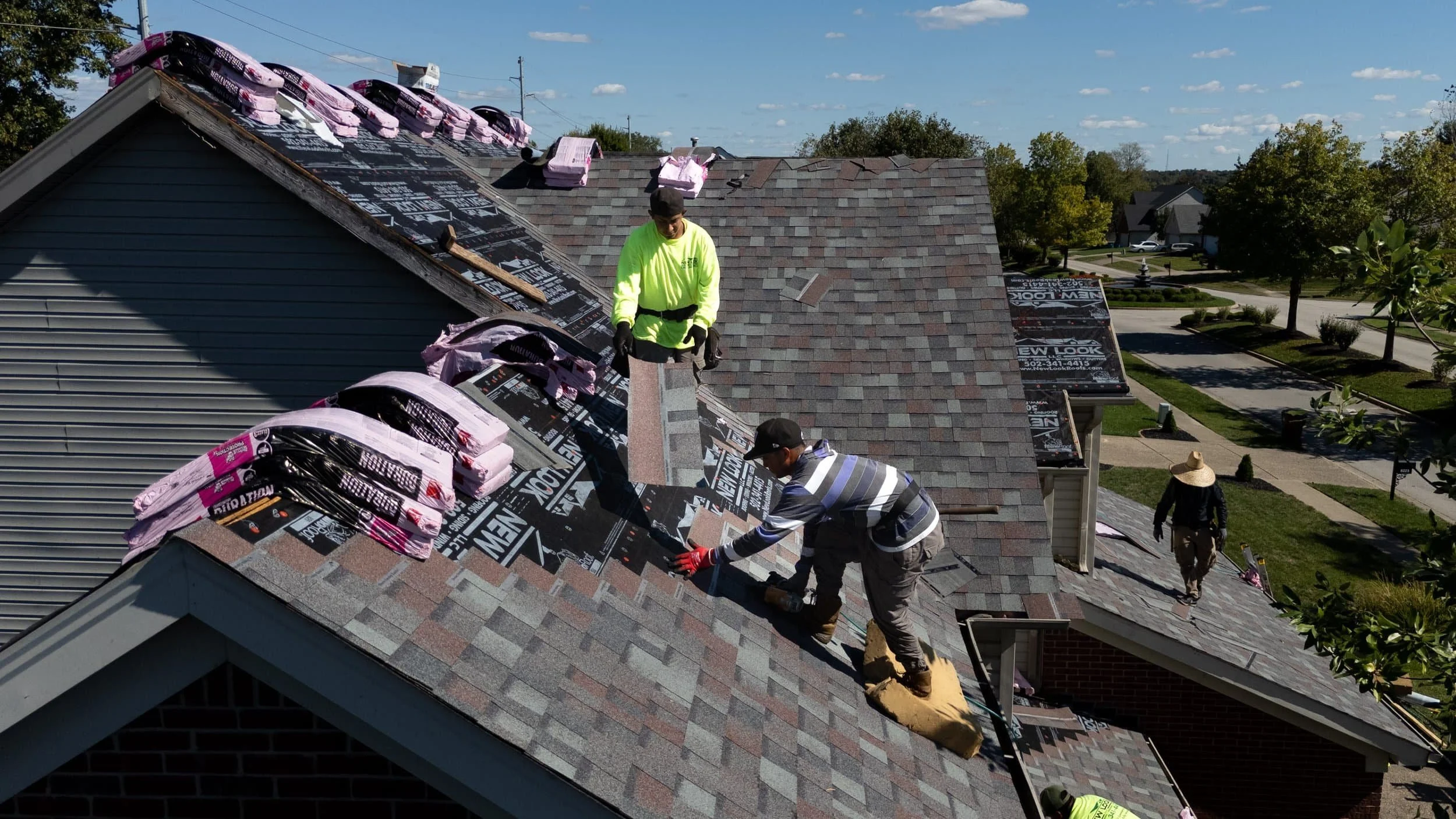 New Look Roof installer laying new asphalt shingles on a Louisville home during a roof replacement