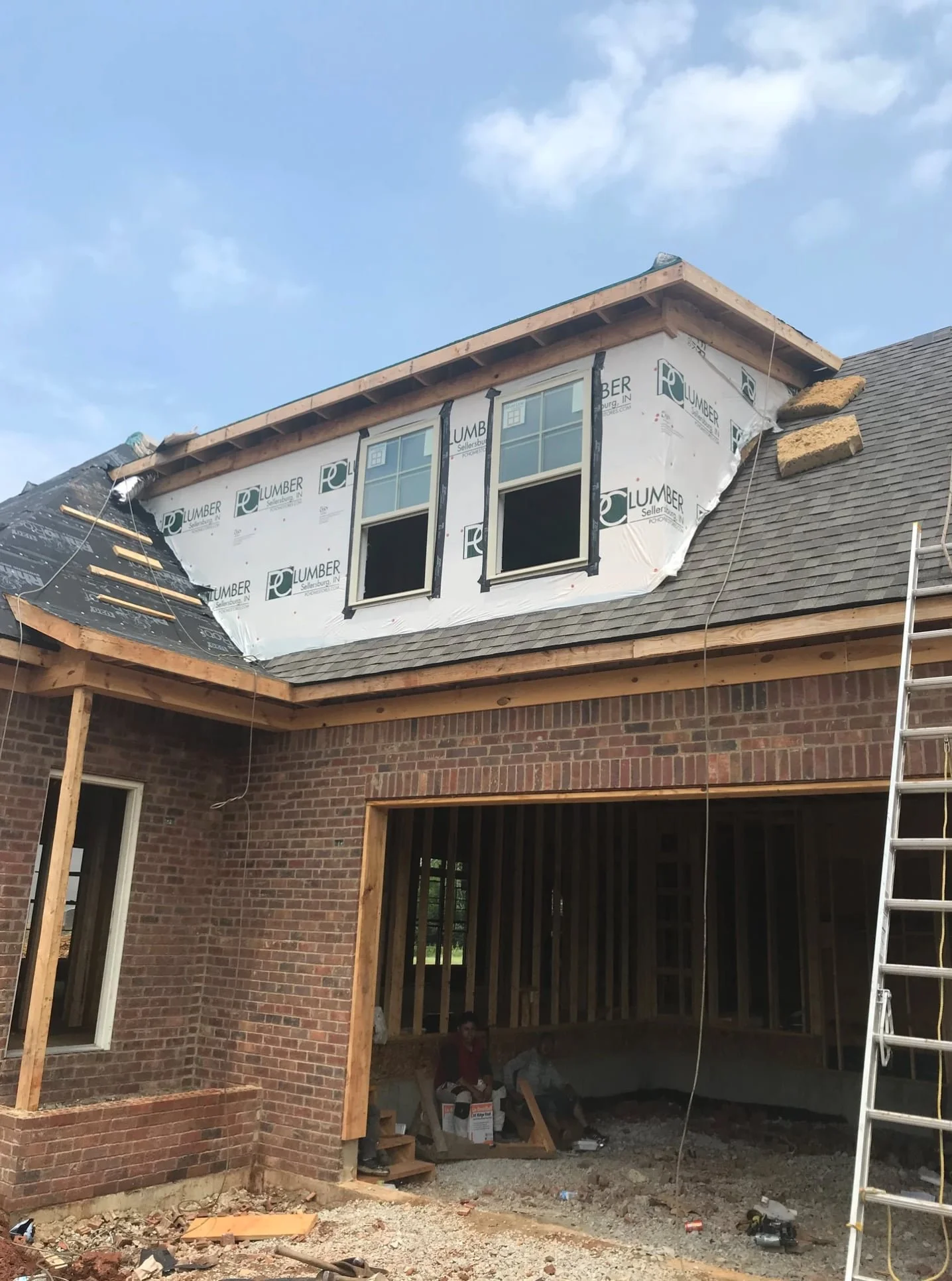 roofing contractor on ladder installing shingles