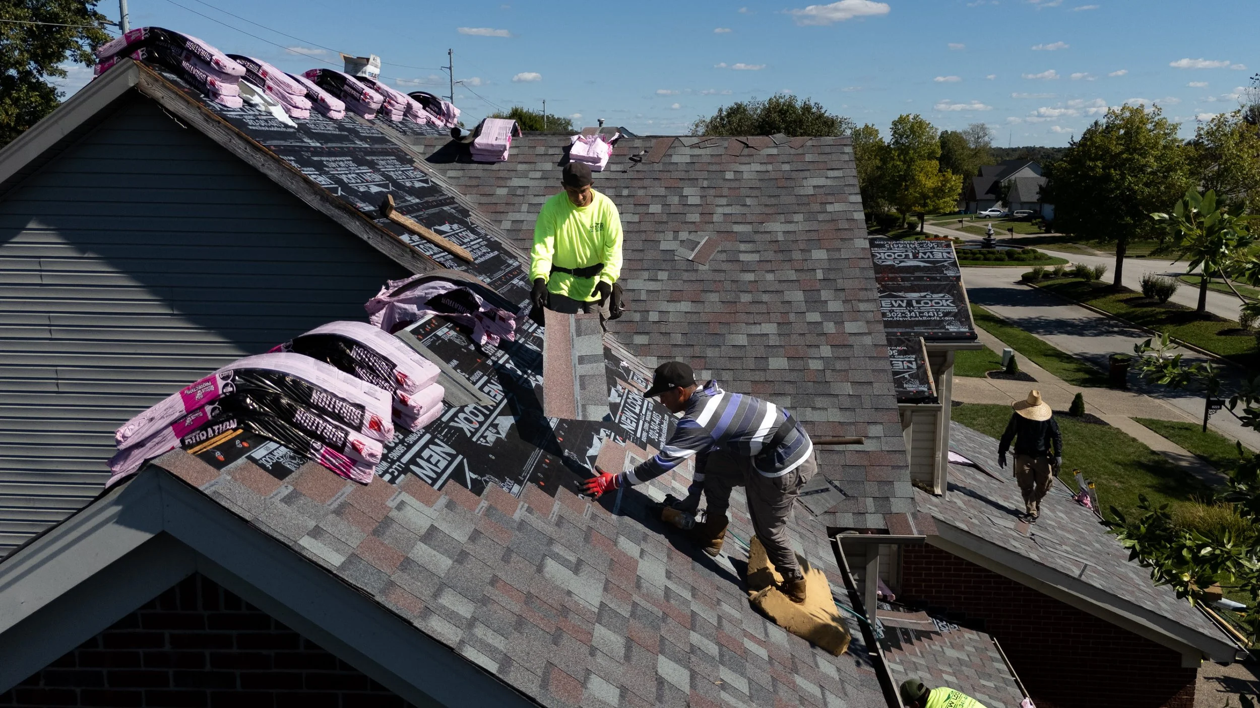 New Look Roof installer laying new asphalt shingles on a Louisville home during a roof replacement