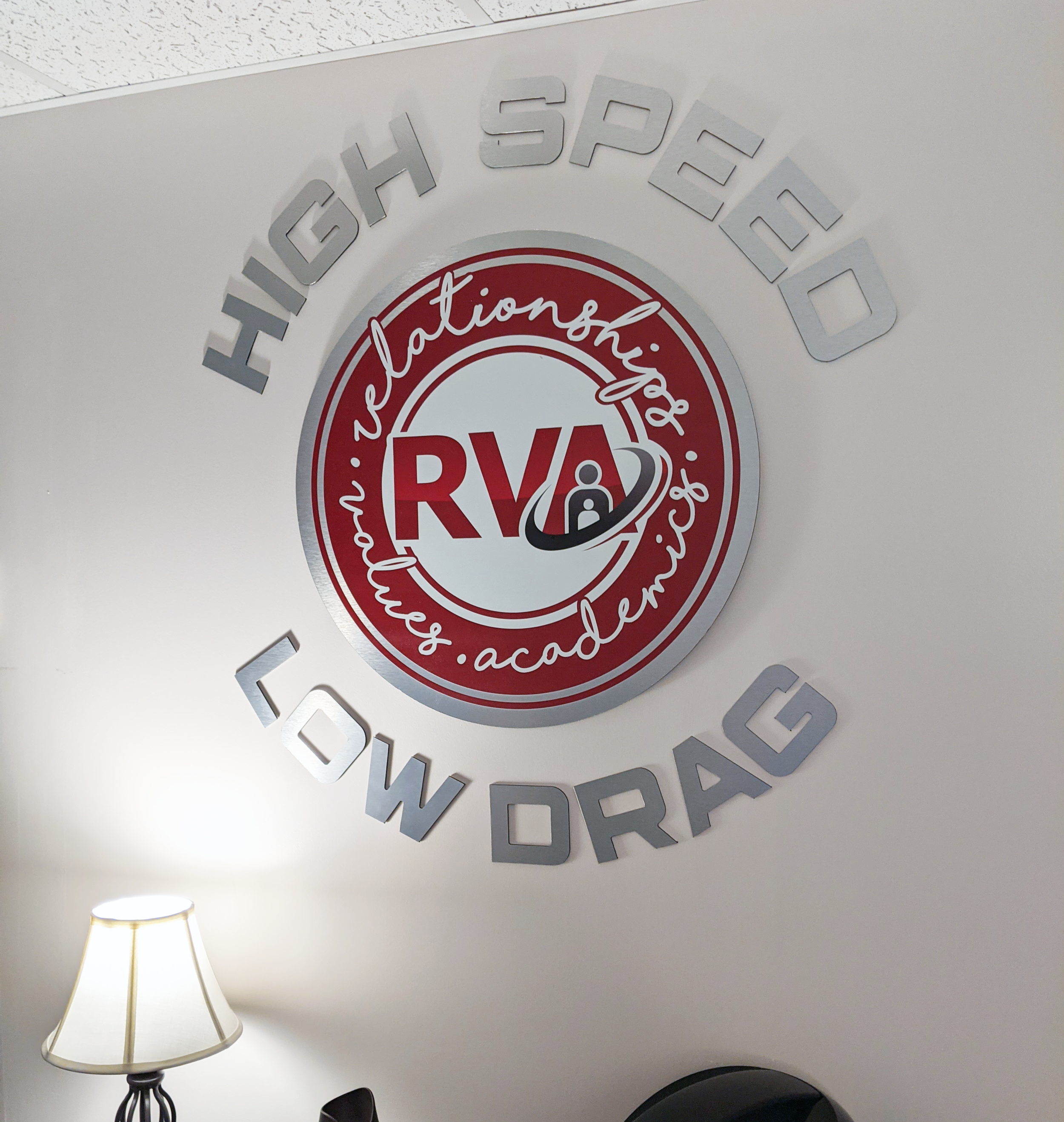  Rural Virtual Academy (RVA) custom circle logo sign and “High Speed, Low Drag” lettering printed on brushed aluminum and router cut to shape by SUN Printing. 