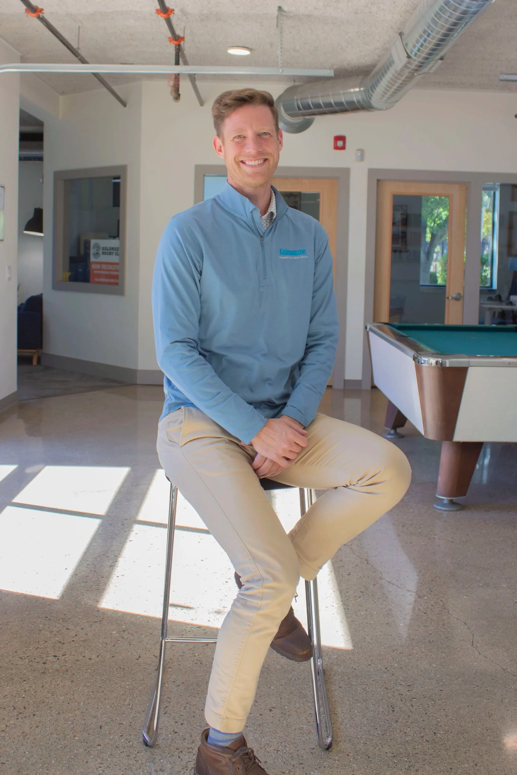 Chad VanDerwall, Associate Broker at Kalamazoo Commercial Real Estate, sitting in a chair.