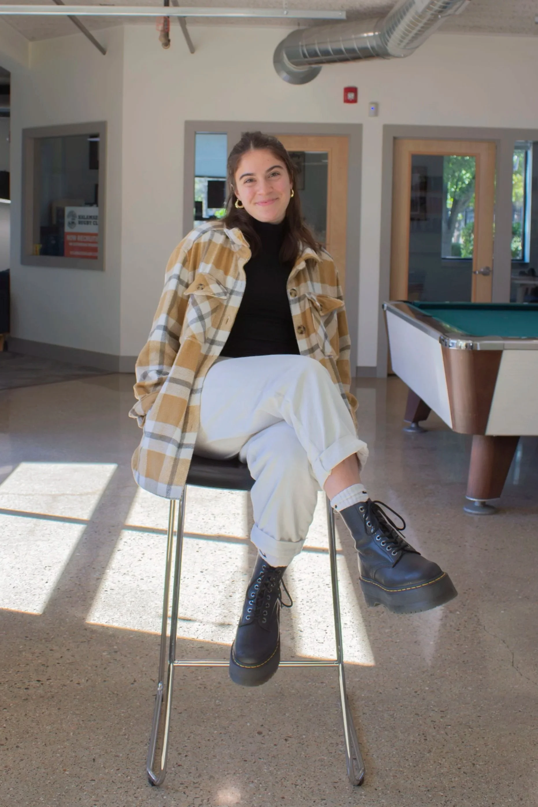 Olivia Erlandson, Accounting Assistant at Kalamazoo Commercial Real Estate, sitting in a chair.