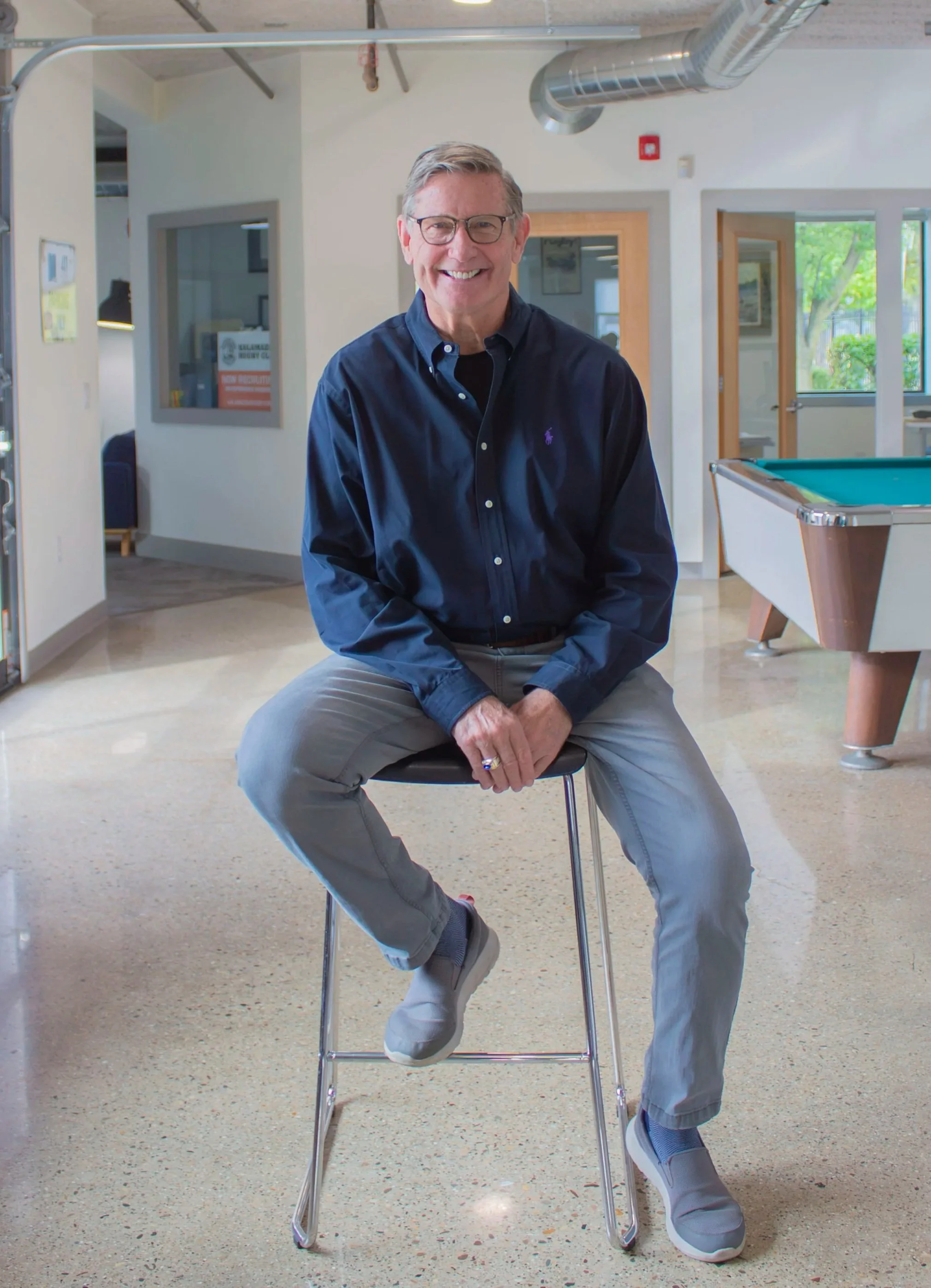 Jeff Chrystal, Associate Broker at Kalamazoo Commercial Real Estate, sitting in a chair.