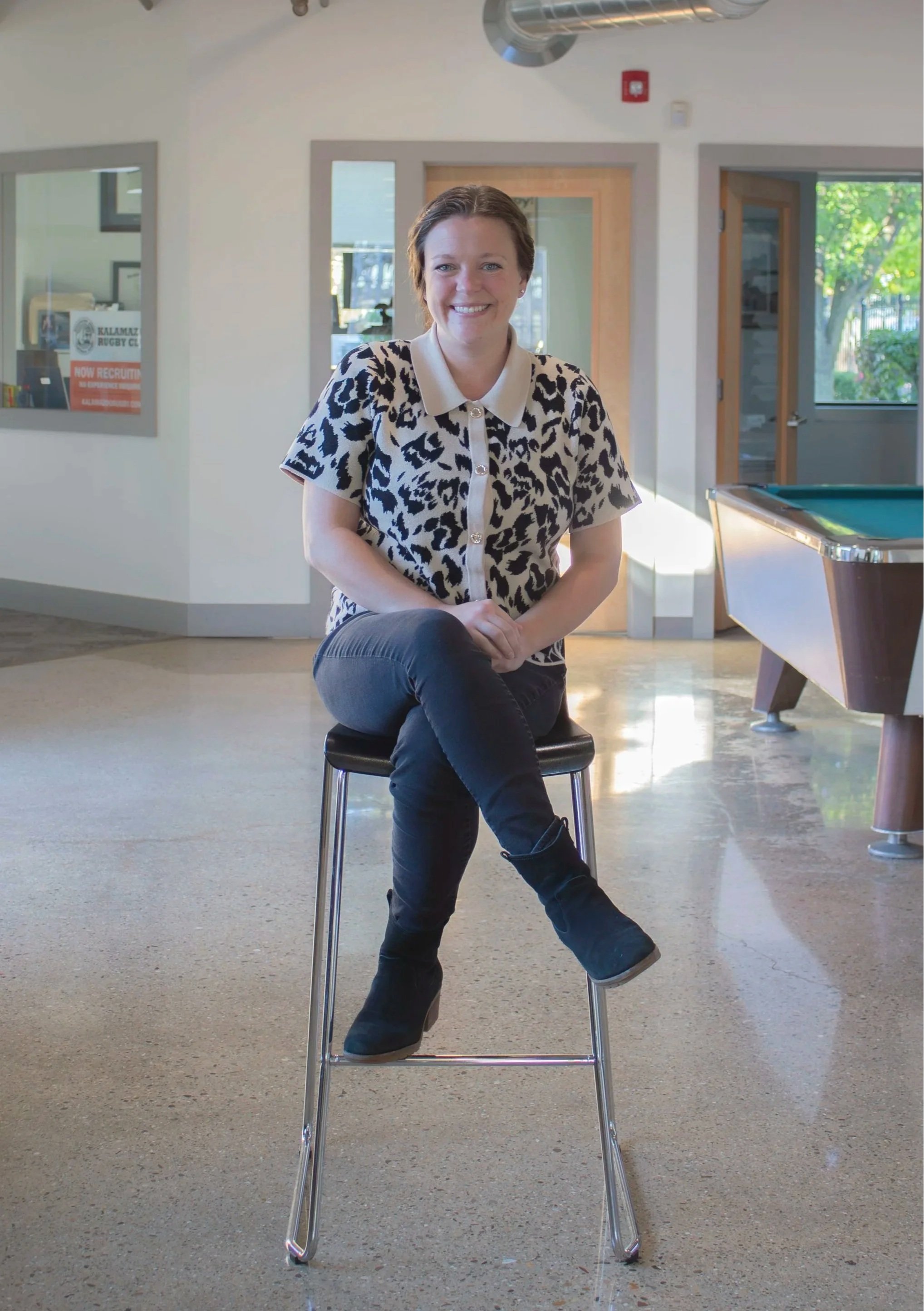 Carolyn Hawkins, Property Manager at Kalamazoo Commercial Real Estate, sitting in a chair.