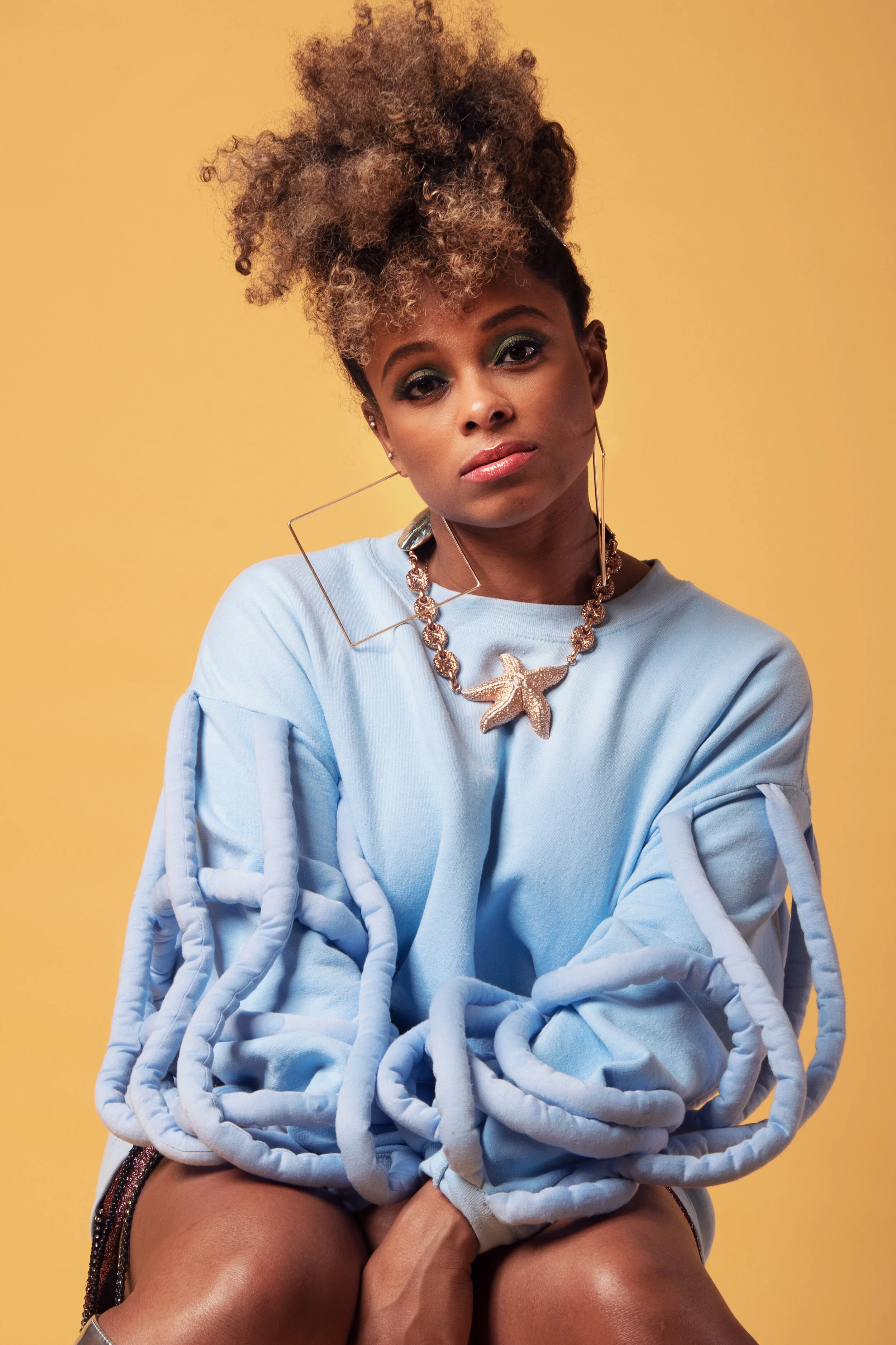 Fleur East for Darkus Magazine — Blue faux fur on ochre