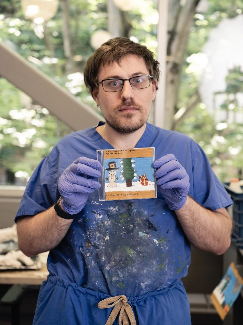 Headshot of Artist Aaron Cunningham Holding Artwork