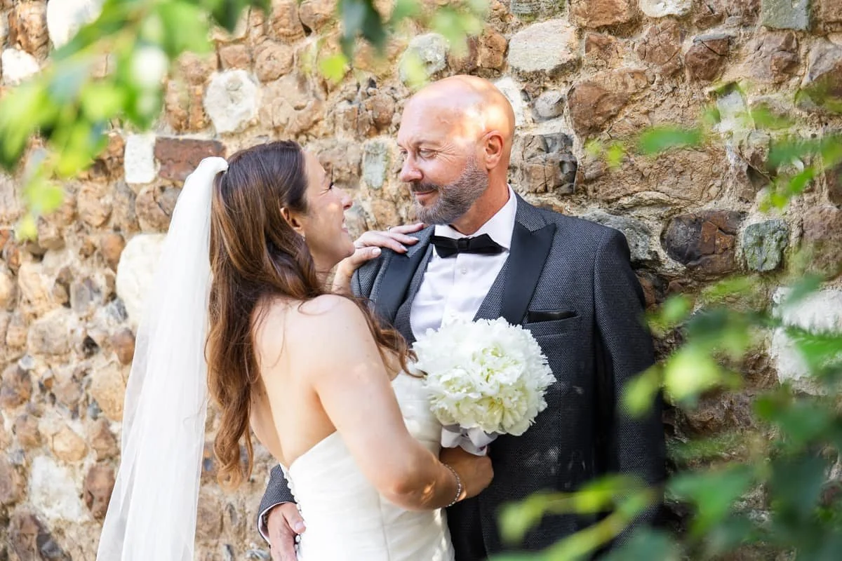 wedding couple standing by interesting stone wall