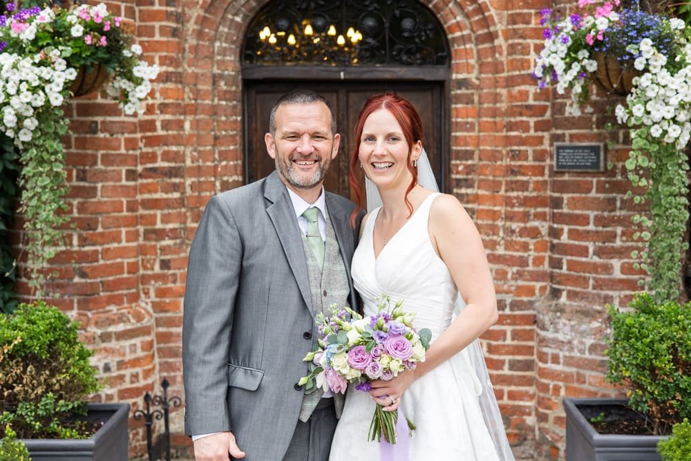 portrait of bride and groom outside manor house