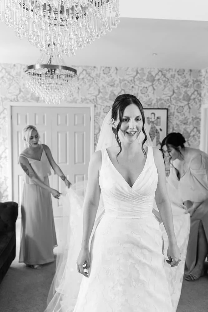 bridesmaids fluffing the wedding dress