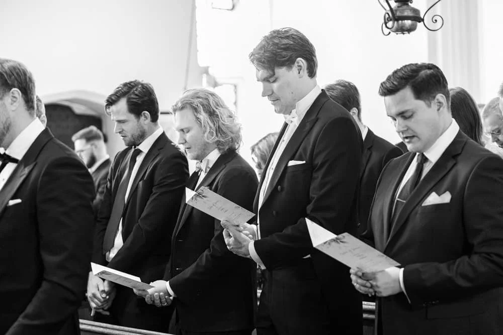 guests standing singing hymns during wedding ceremony