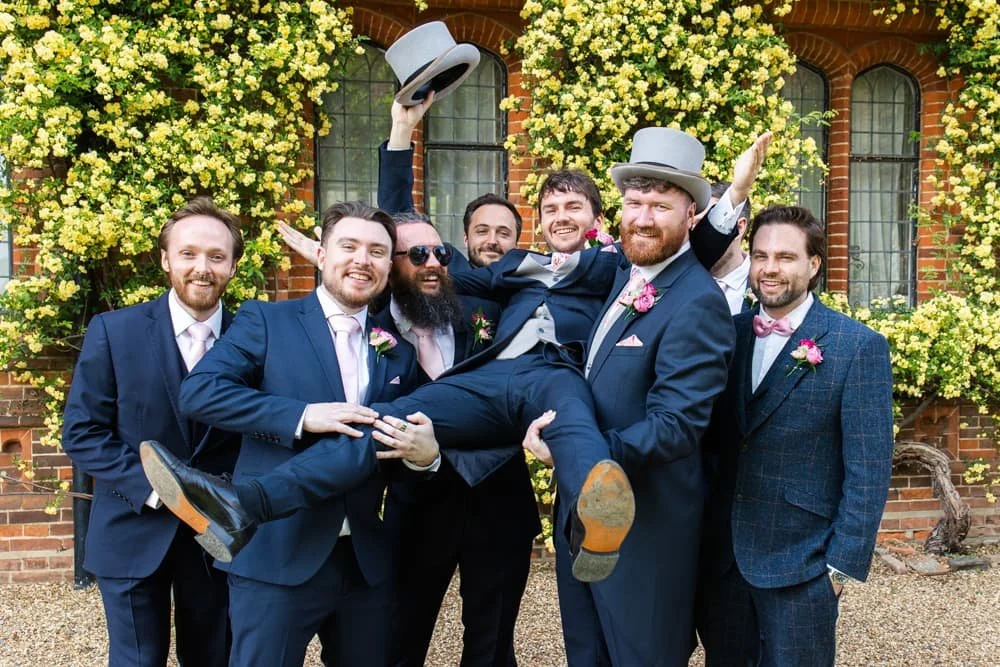 groomsmen picking groom up
