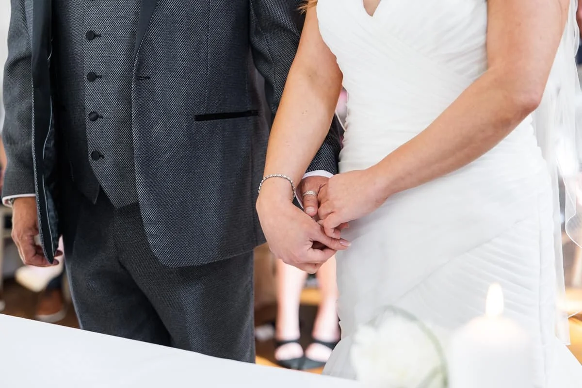 close up photo of bride and groom holding hands during wedding ceremony