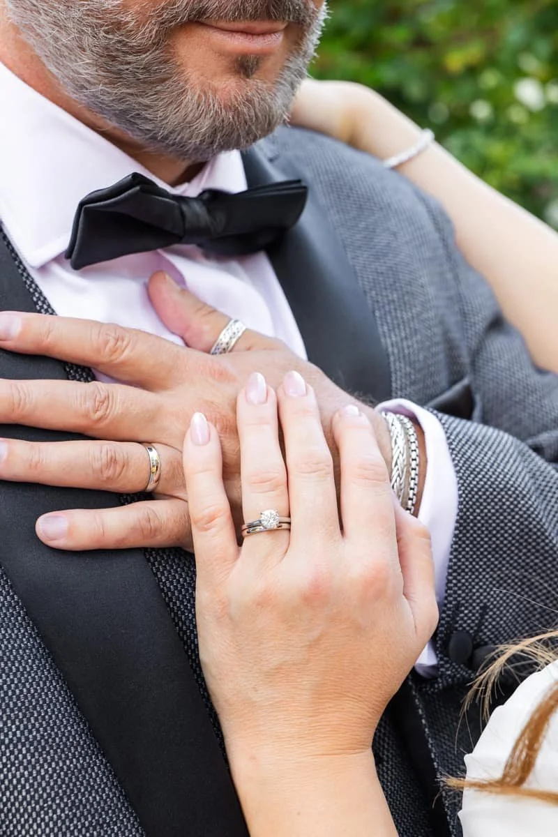 close up photo of wedding rings on their hands