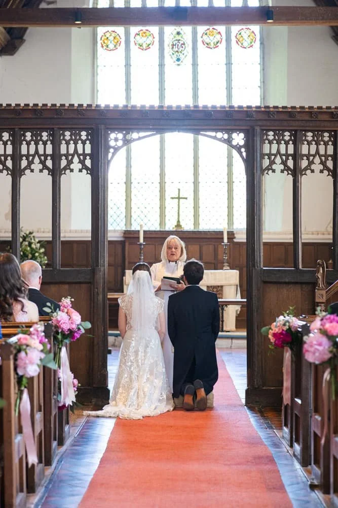 couple kneeling for prayers at church wedding ceremony