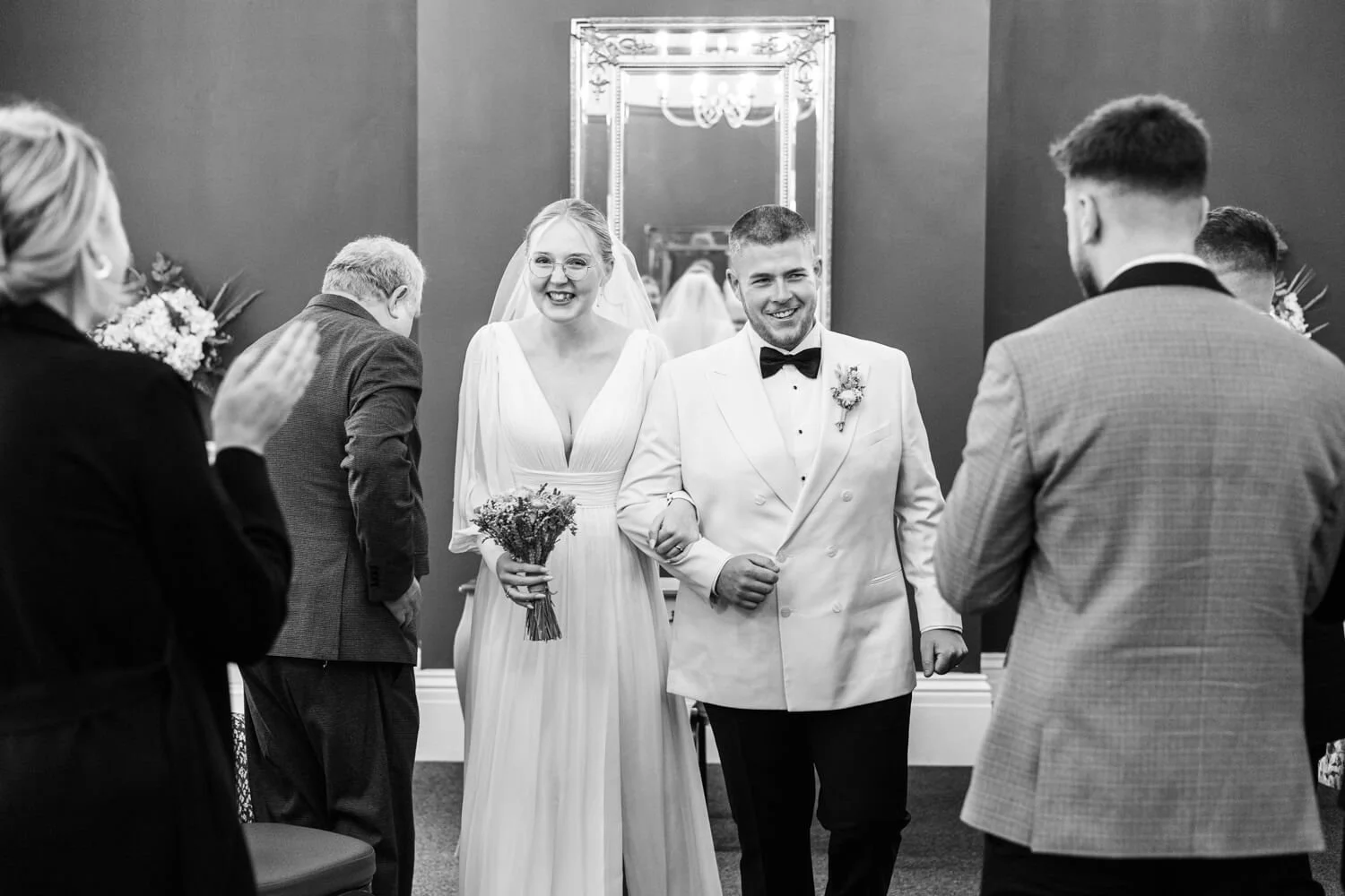 black and white photo of wedding couple exiting ceremony