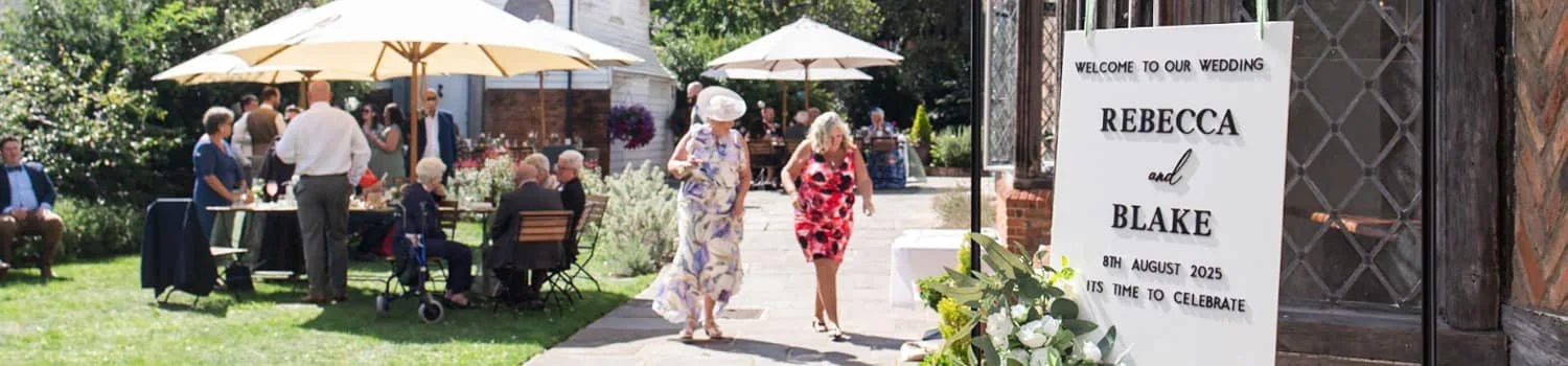 wedding welcome sign with guests in the background