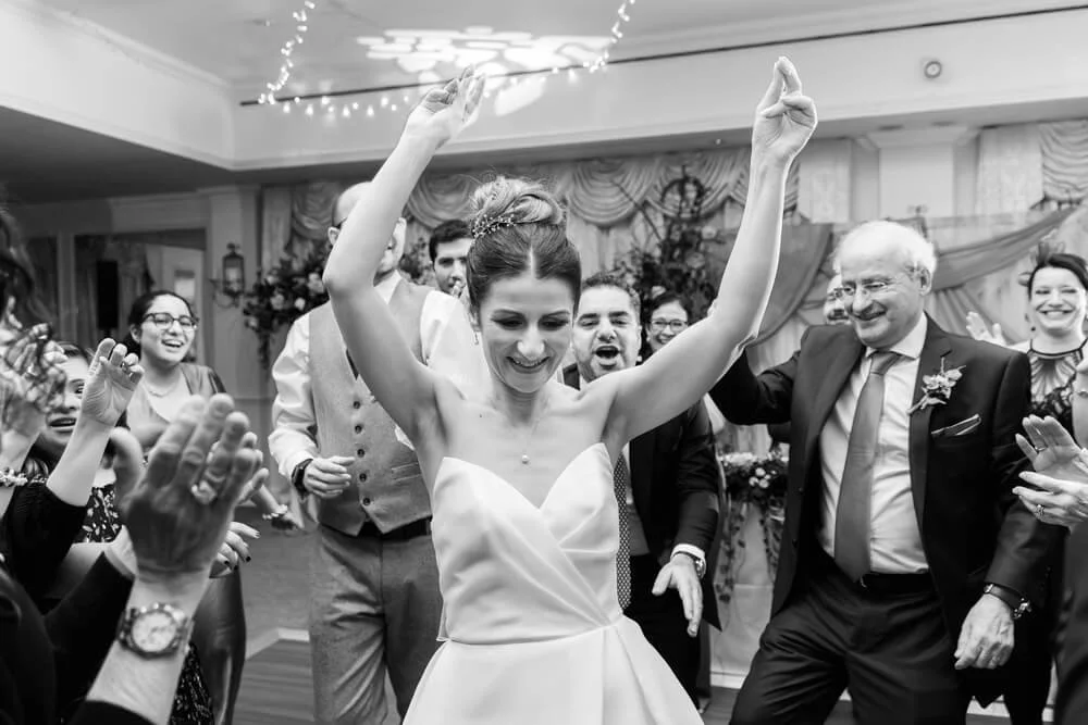 Bride dancing at her wedding surrounded by family