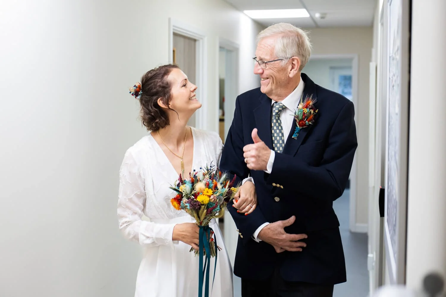 bride’s father giving her a thumbs up before wedding ceremony