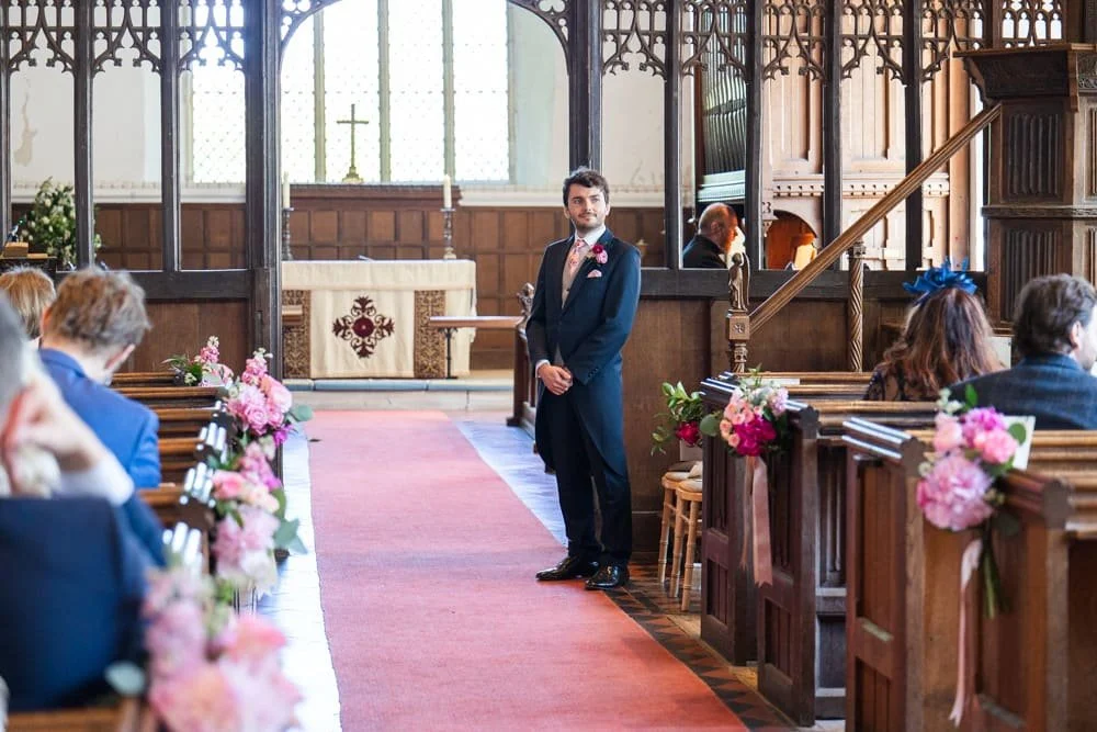 groom waiting at the front of the church at Layer Marney