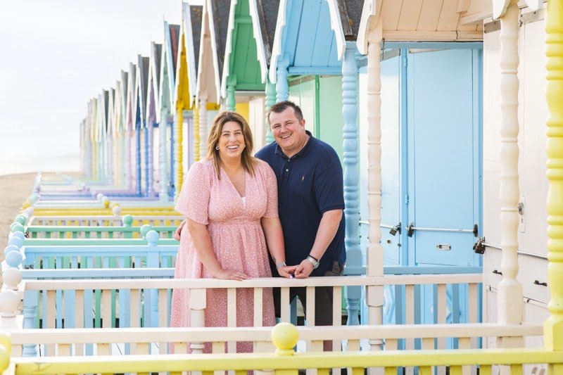 couple portrait on Mersea beach, with colourful beachhuts