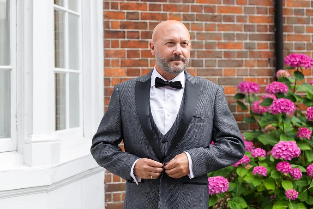 groom doing up his jacket ready for his wedding