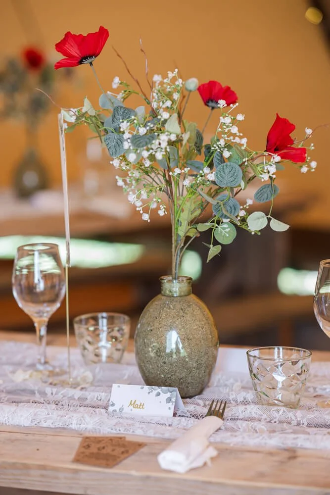red poppies in vase on table
