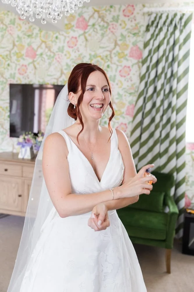 bride putting perfume on at manor house