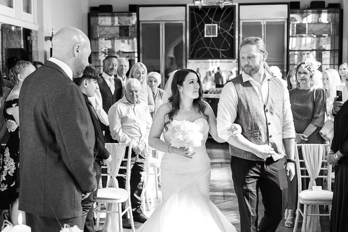 bride sharing meaningful moment with brother as they walk down the aisle