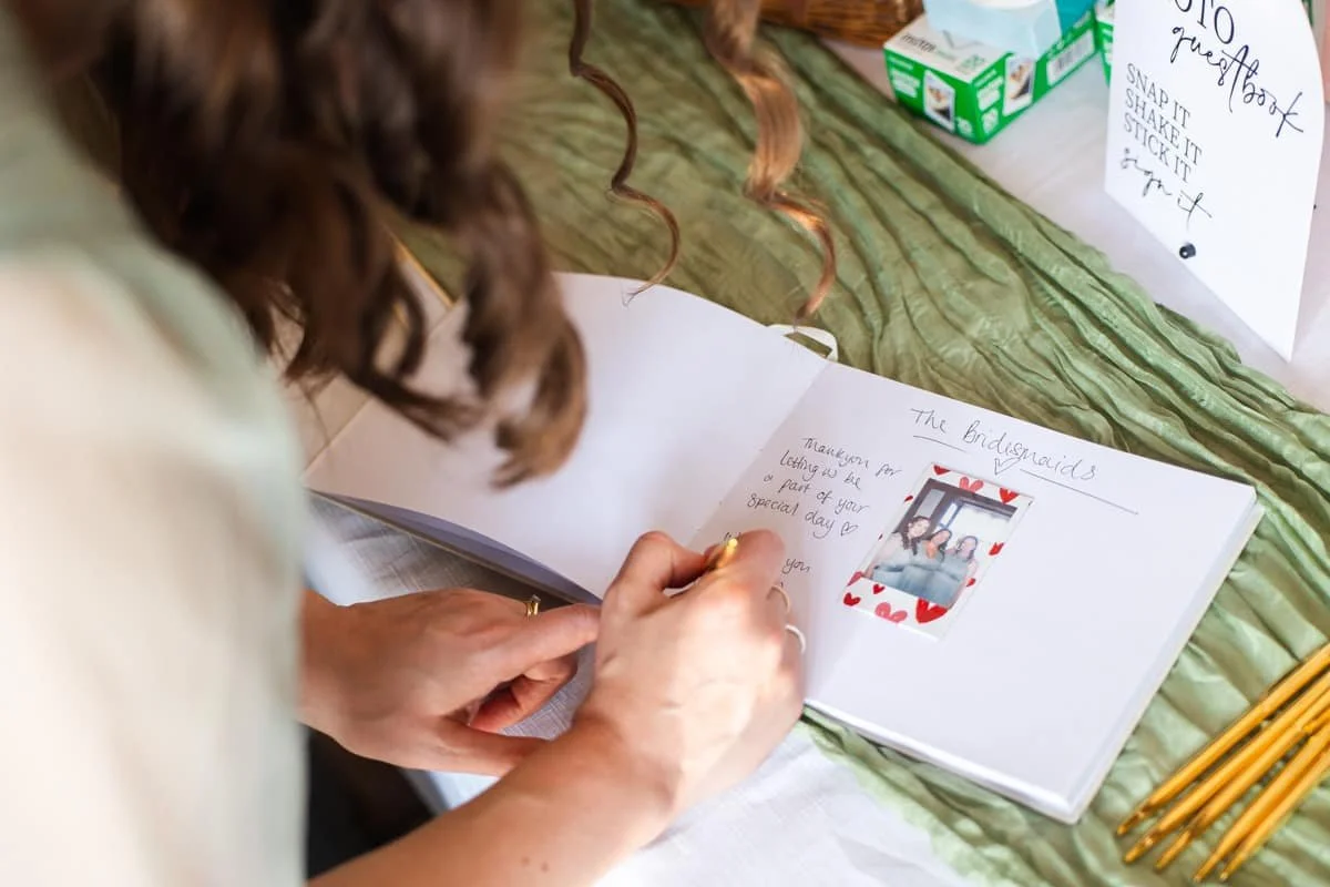 bridesmaids leaving message in wedding guest book