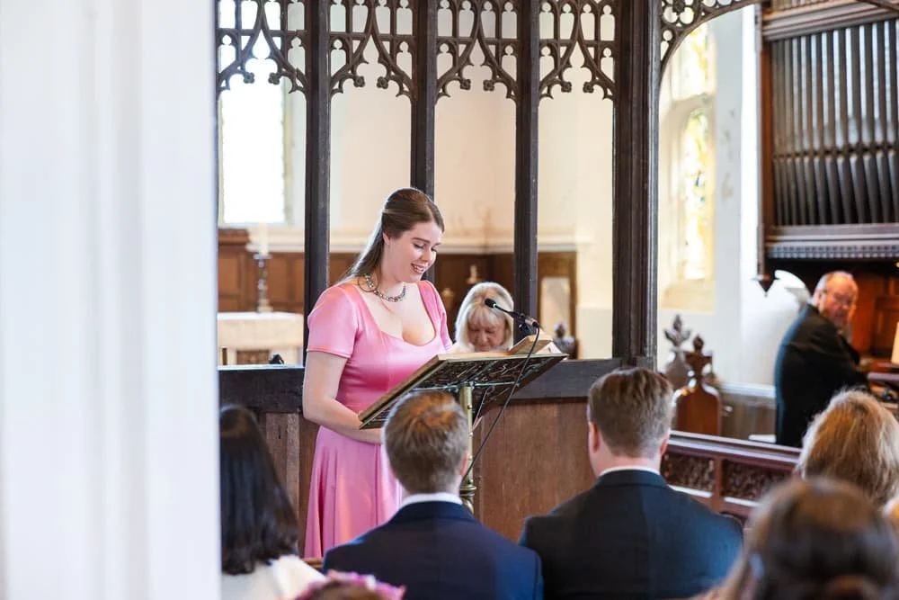 bridesmaid doing a reading at church ceremony