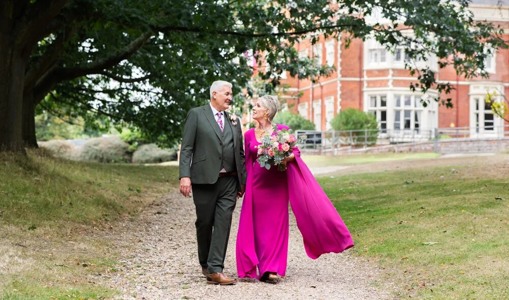 bride and groom walking outside wivenhoe house