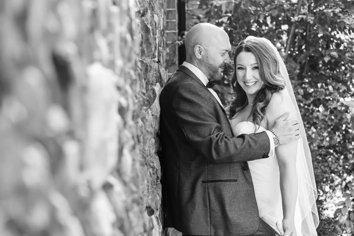 groom looking at bride while she looks at camera