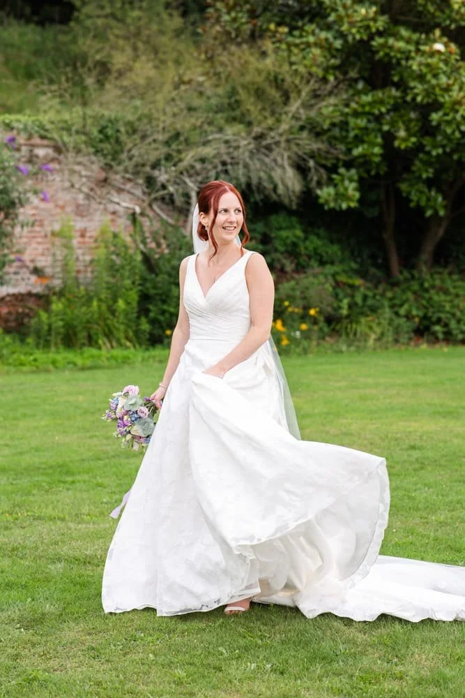 portrait of bride outside swishing her dress