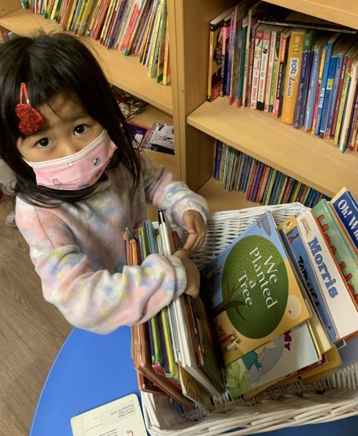 girl flipping through basket of books.jpg