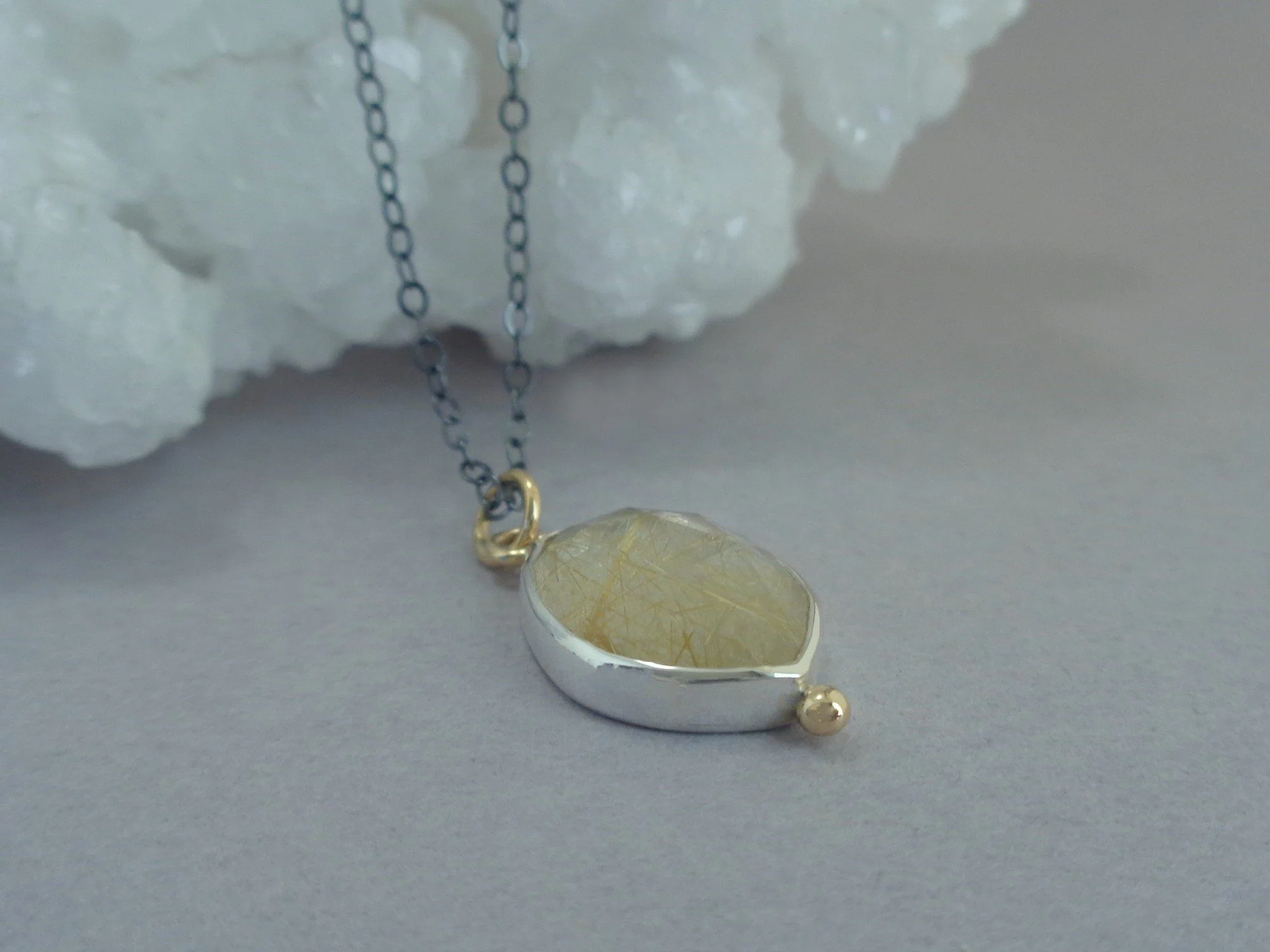 silver and gold pendant with rutilated quartz x.jpg