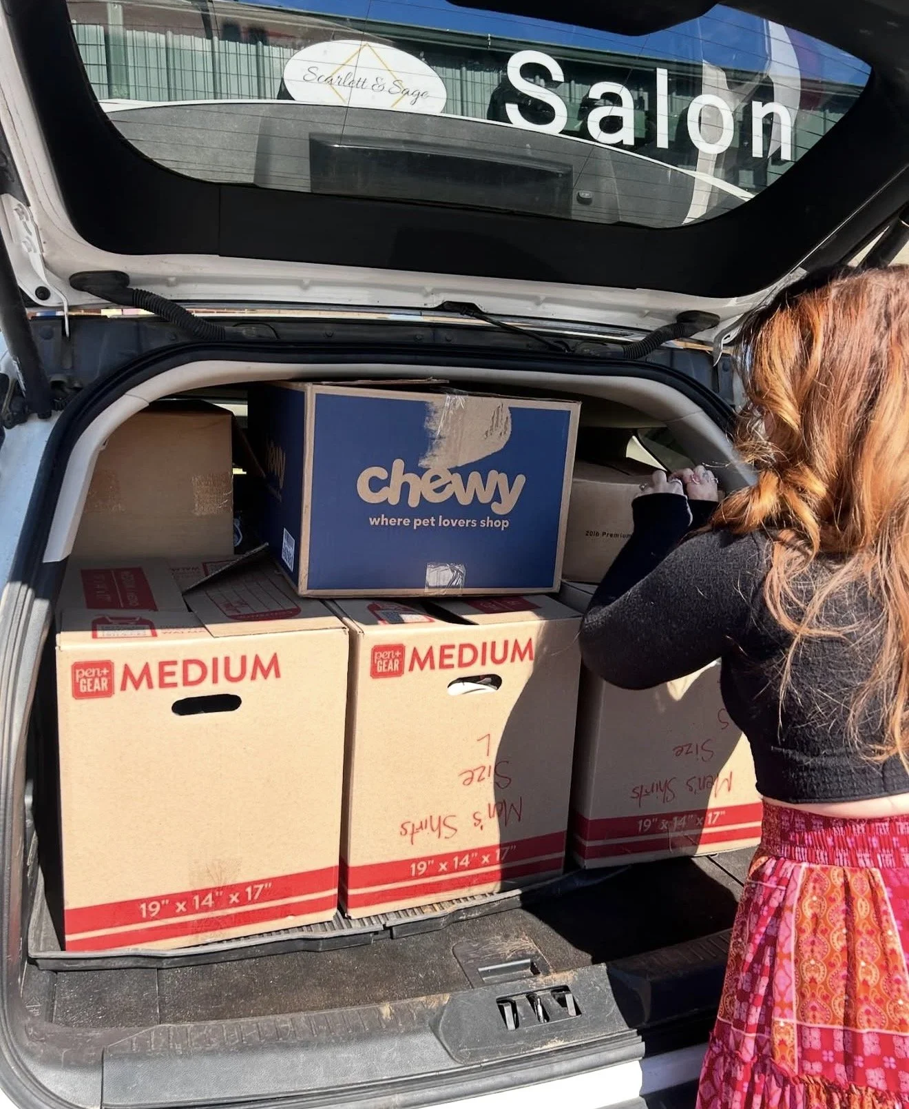Open car trunk filled with boxes, labeled as medium size, with several boxes also placed inside.