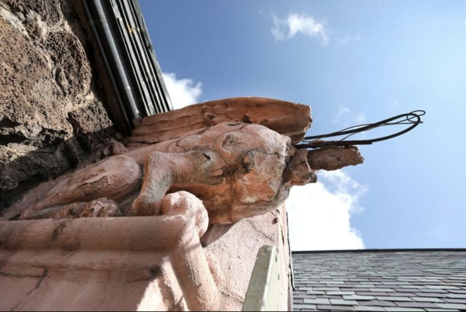  A headless gargoyle with its body cracked and scabby where the cast concrete it is made from is degrading sits at the edge of the roofline of the Nativity of the Blessed Virgin Mary chapel recently. Efforts are underway to restore the church but fir