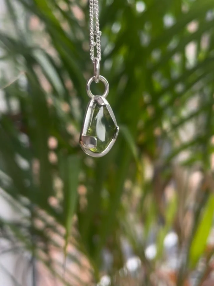 First commission of the year is finished and what a lovely one it was to work on! 

Kim contacted me to see if I could turn her loose peridot stone into a pendant. Completely irregular shaped with multiple rounded edges, I tried to come up with a des