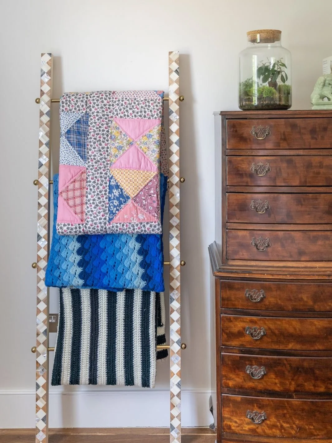 A beautiful Georgian tallboy sits at the heart of the guest bedroom, a cherished vintage piece in our client&rsquo;s curated collection. We paired this with a mother-of-pearl detailed ladder for a styling element, creating a purposeful place for the 