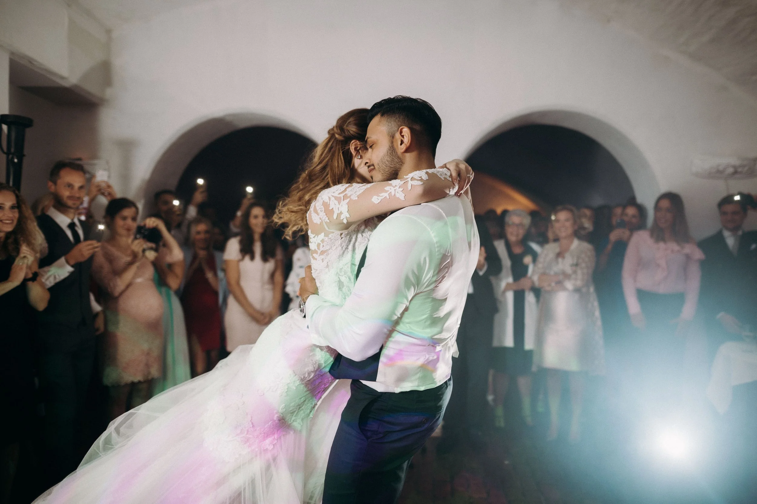 Bride and groom sharing a romantic first dance surrounded by guests during the wedding reception at Kasteel Heeswijk.