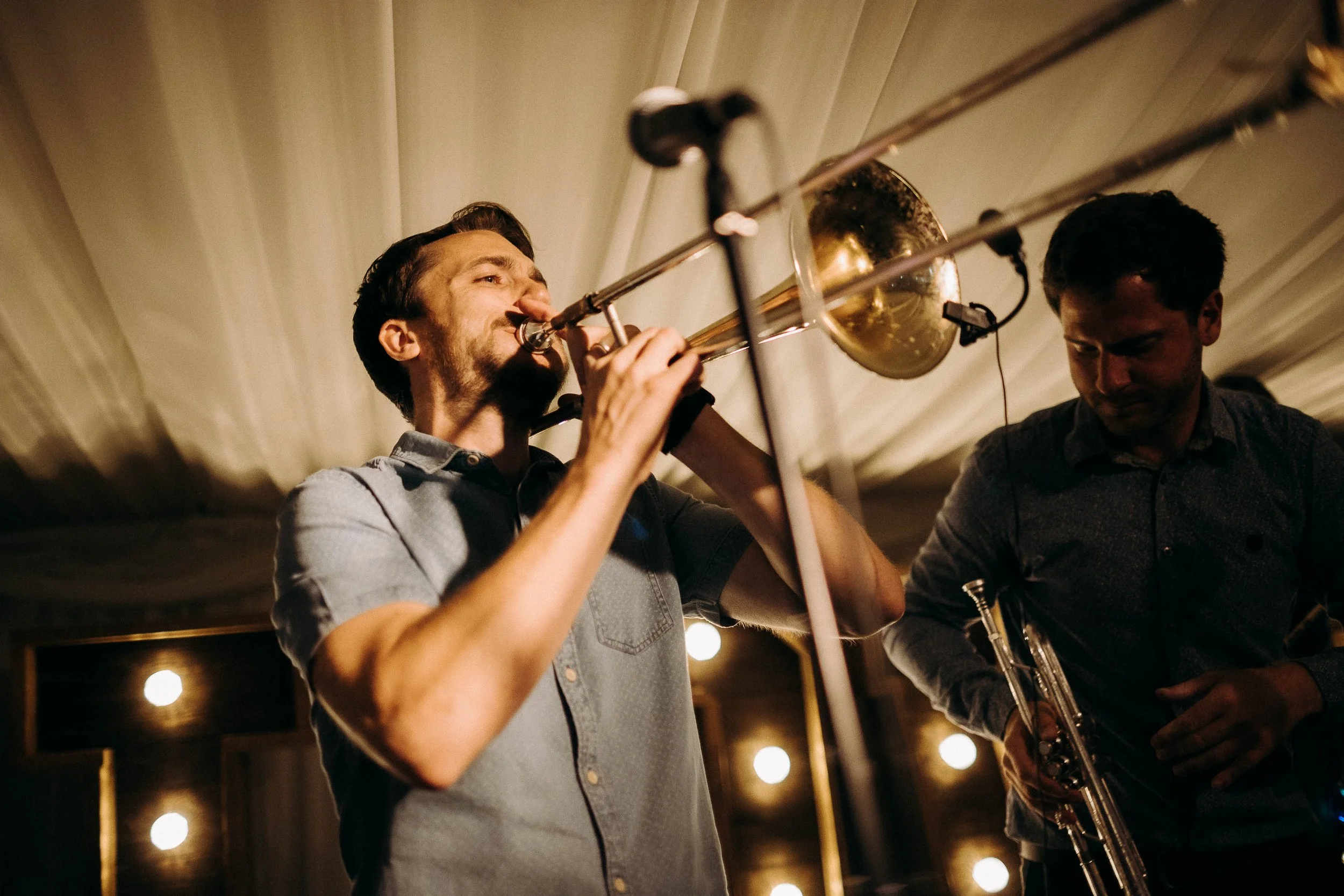 Live band trombone player performing during a wedding reception, energising the dance floor at Shearsby Bath.